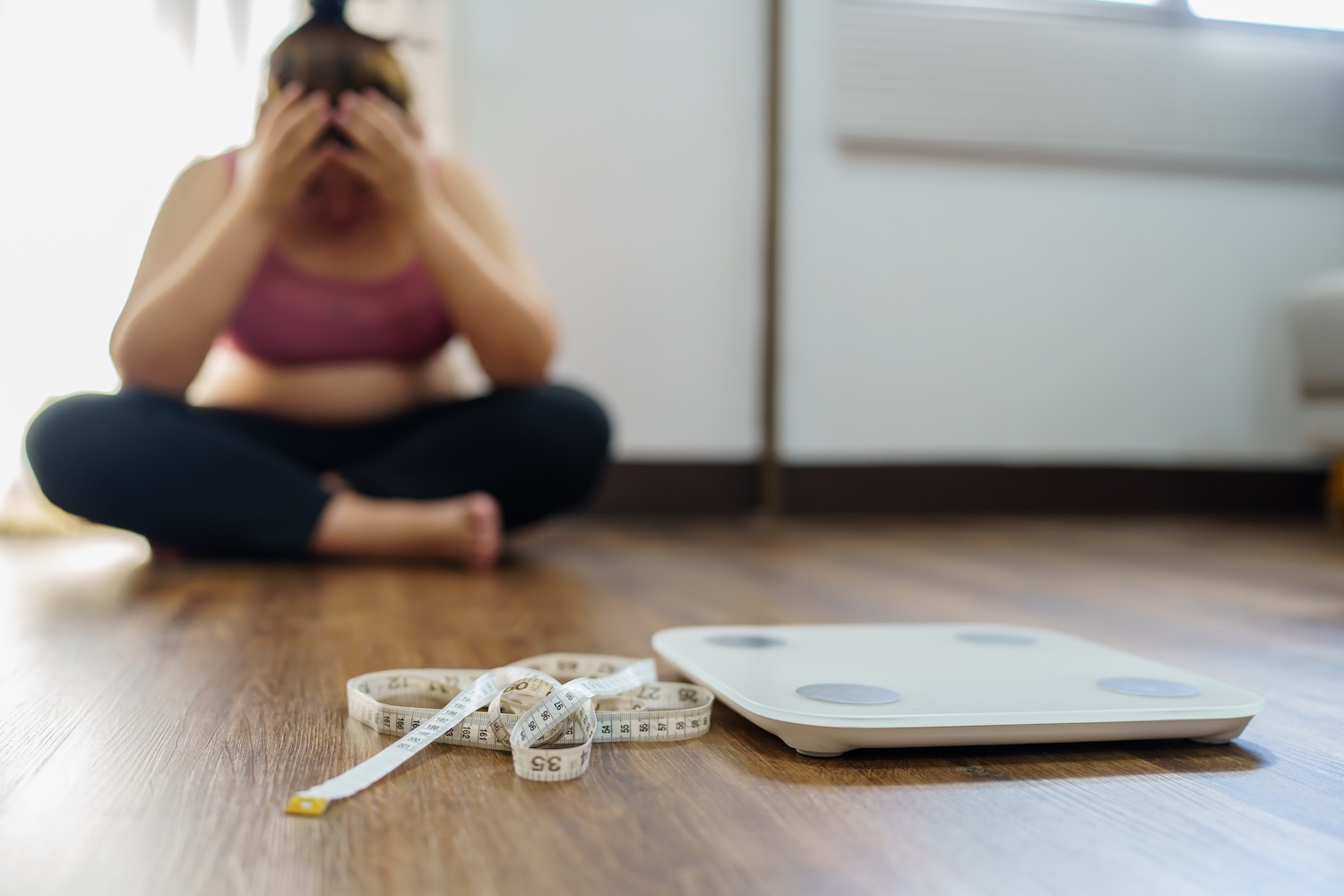 Obese Woman with fat upset bored of dieting Weight loss fail  Fat diet and scale sad asian woman on weight scale at home weight control.